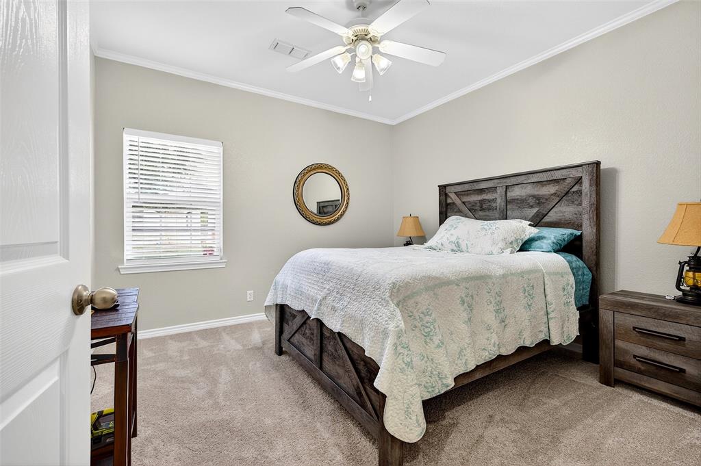 202 Hillside Lindsay, TX 76250 - Photo 15 of 37 a bedroom with a bed and a chandelier