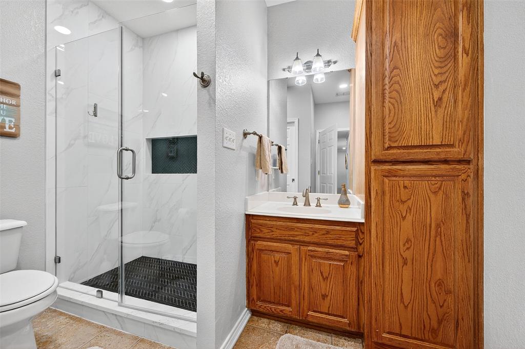 202 Hillside Lindsay, TX 76250 - Photo 17 of 37 a bathroom with a granite countertop sink a toilet and shower