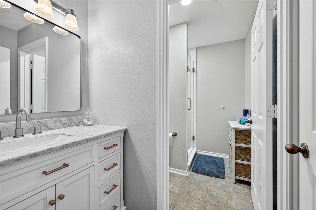 202 Hillside Lindsay, TX 76250 - Photo 24 of 37 a en suite bathroom with a granite countertop sink and a mirror