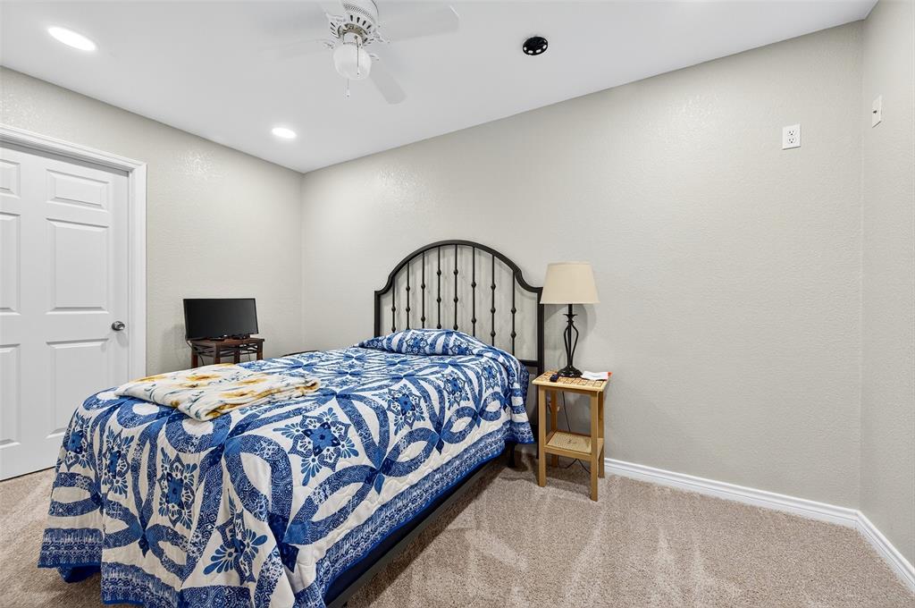 202 Hillside Lindsay, TX 76250 - Photo 25 of 37 a bedroom with a bed and a chandelier