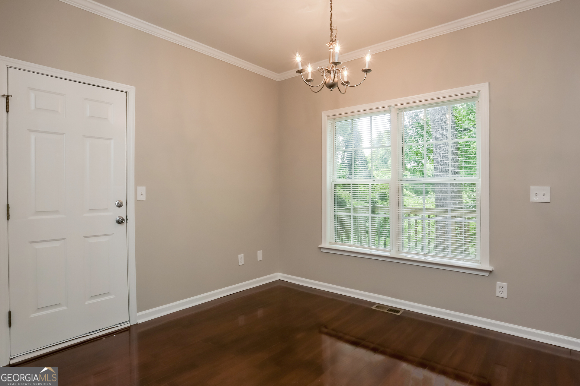 2041 Pryor Road Southwest Atlanta, GA 30315 - Photo 5 of 17 a view of an empty room with wooden floor and a window