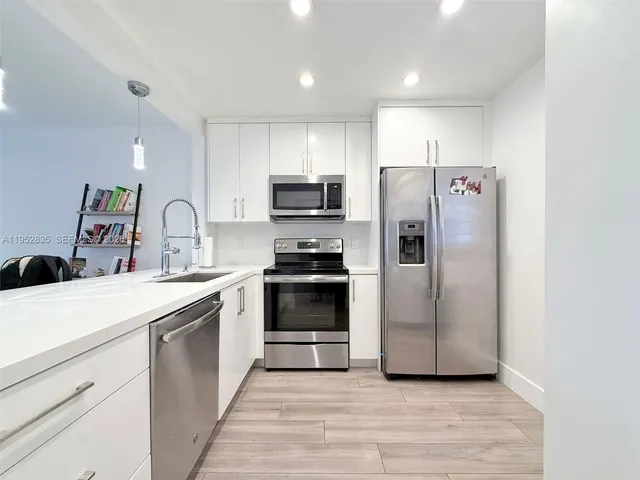 a kitchen with stainless steel appliances a refrigerator sink and stove