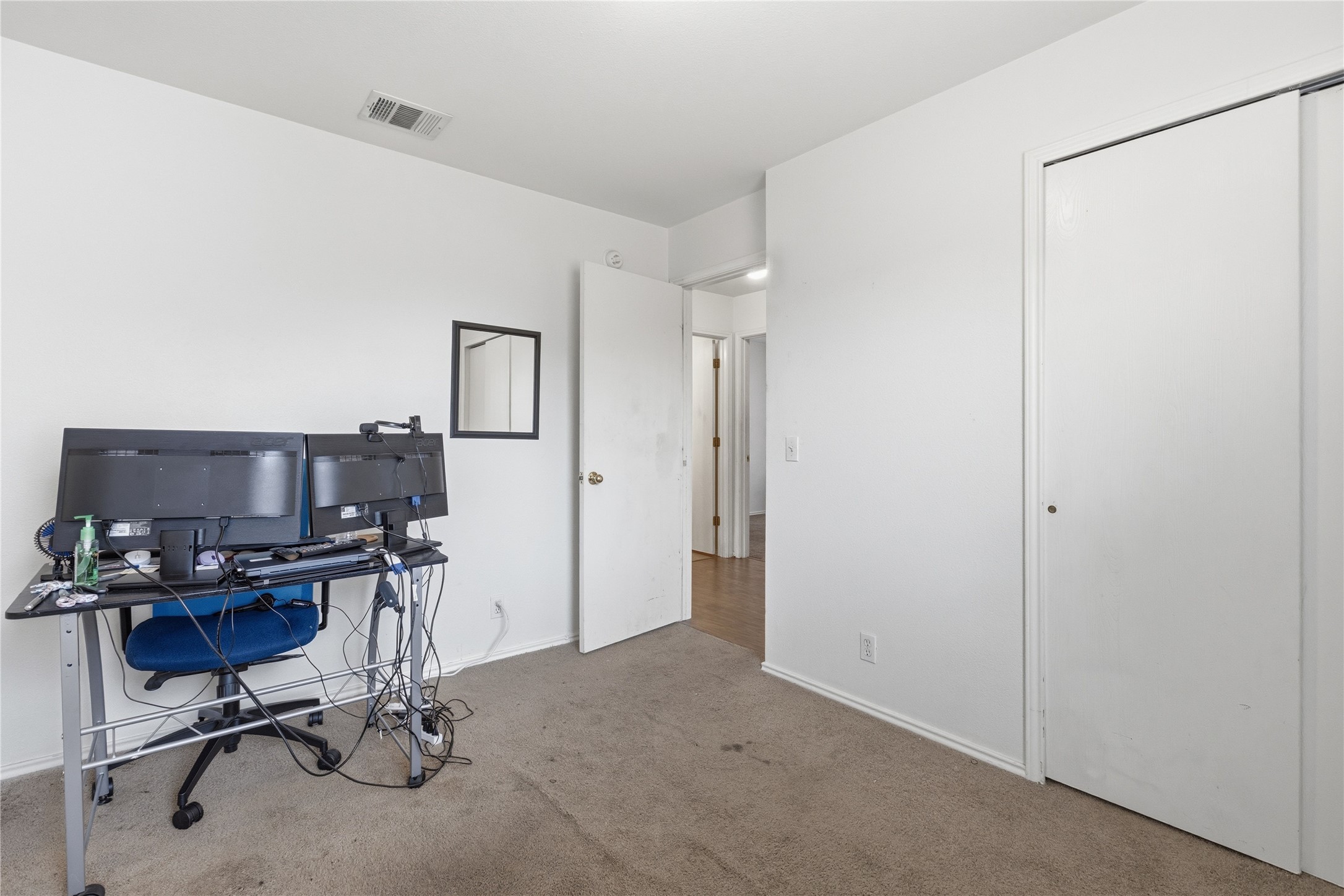 16112 Hamilton Point Circle Manor, TX 78653 - Photo 13 of 27 Carpeted room featuring a white interior door, white sliding closet doors, white baseboards, and a ceiling-mounted vent