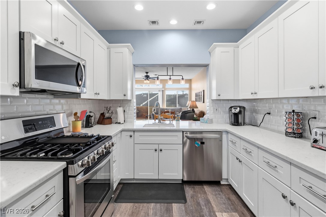 3350 Pheasant Canyon Way, Unit 1008 Laughlin, NV 89029 - Photo 14 of 80 Recently remodeled kitchen with appliances with stainless steel finishes, white cabinetry, light quartz counters, plank flooring, and custom recessed lighting