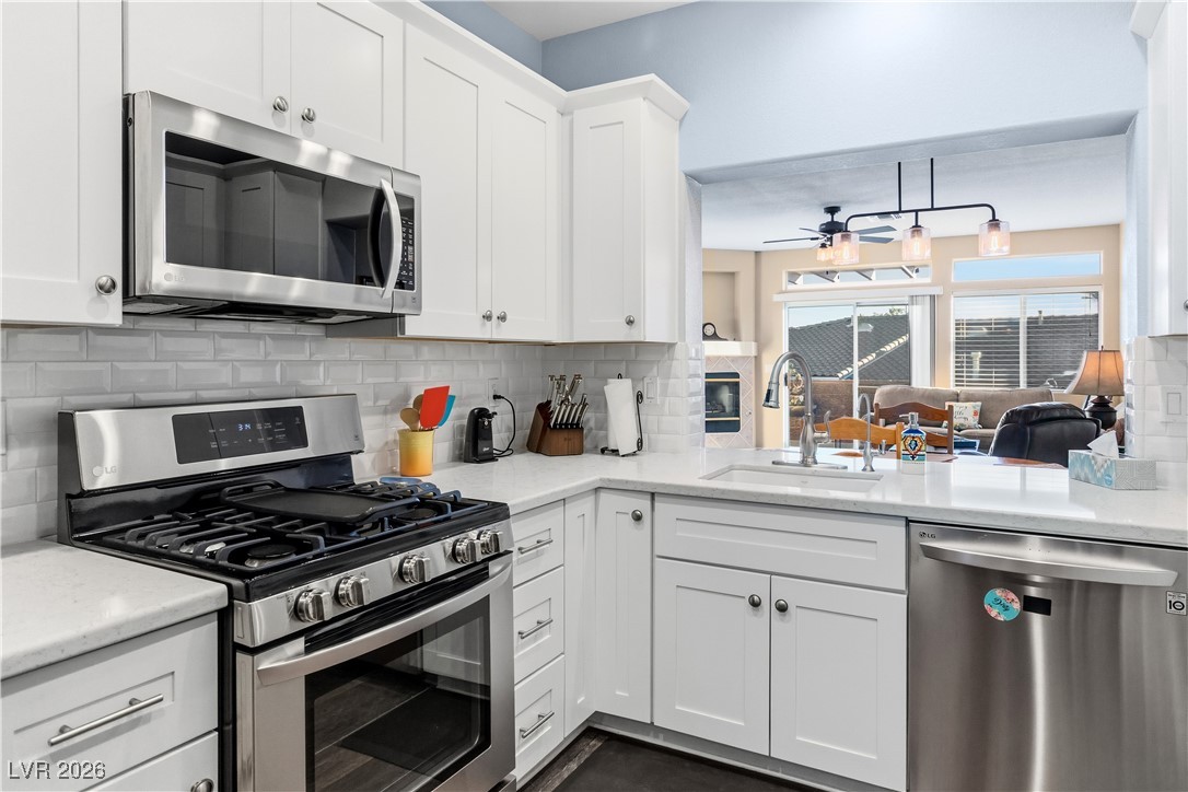 3350 Pheasant Canyon Way, Unit 1008 Laughlin, NV 89029 - Photo 78 of 80 Kitchen with appliances with stainless steel finishes, white cabinets, backsplash, and open floor plan