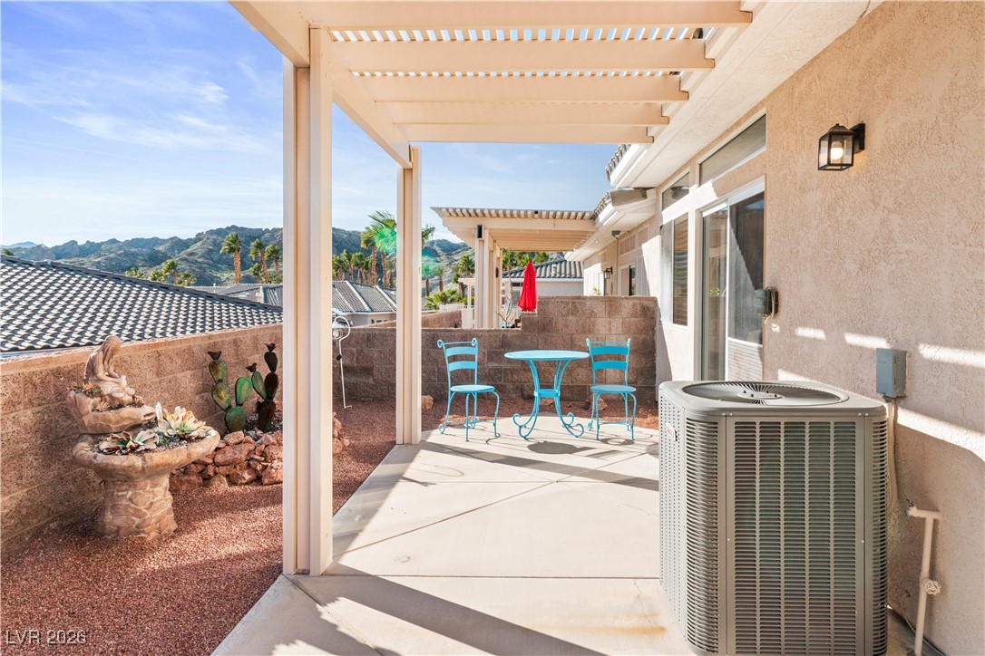 3350 Pheasant Canyon Way, Unit 1008 Laughlin, NV 89029 - Photo 45 of 80 Fenced backyard with a patio, a mountain view, a pergola, and outdoor dining space
