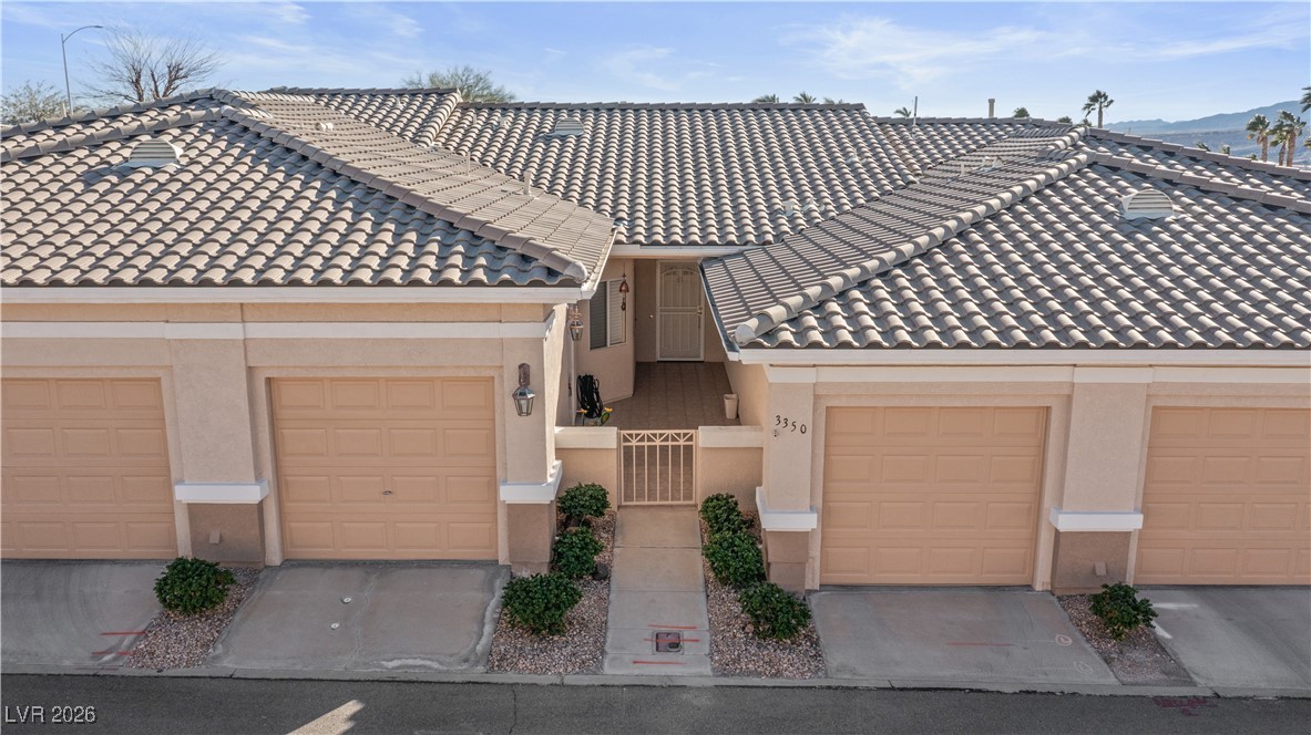 3350 Pheasant Canyon Way, Unit 1008 Laughlin, NV 89029 - Photo 68 of 80 View of front of house featuring stucco siding, a tile roof, a garage, and a mountain view