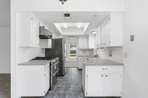 a kitchen with a sink stove and cabinets