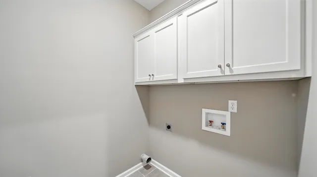 a kitchen with white cabinets and a window