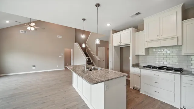 a kitchen with stainless steel appliances granite countertop a sink a stove and a refrigerator