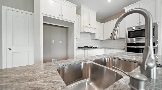 a kitchen with stainless steel appliances granite countertop a sink a microwave and cabinets