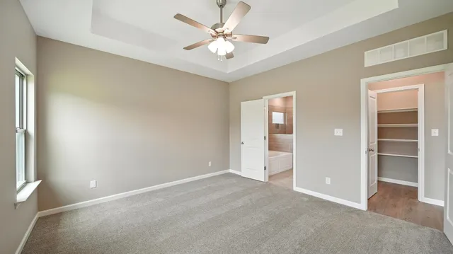 an empty room with closet and a ceiling fan