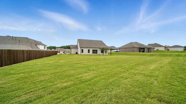 a view of a house with yard and car parked