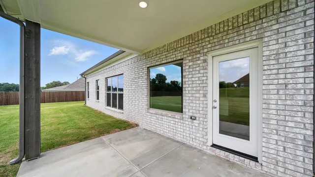 a view of a porch in front of a brick house with a large windows