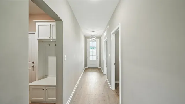 a view of a hallway with wooden floor and staircase