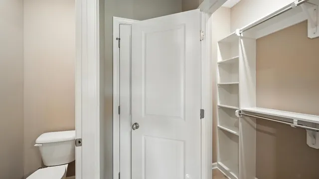 a white toilet sitting next to a shower