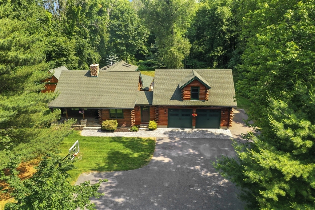 a front view of a house with a garden and trees