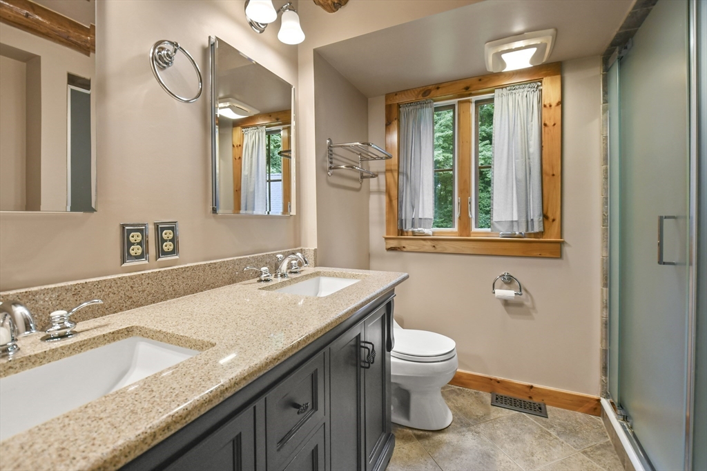 389 Kelly Road Northbridge, MA 01534 - Photo 20 of 40 a bathroom with a granite countertop sink a toilet and a mirror
