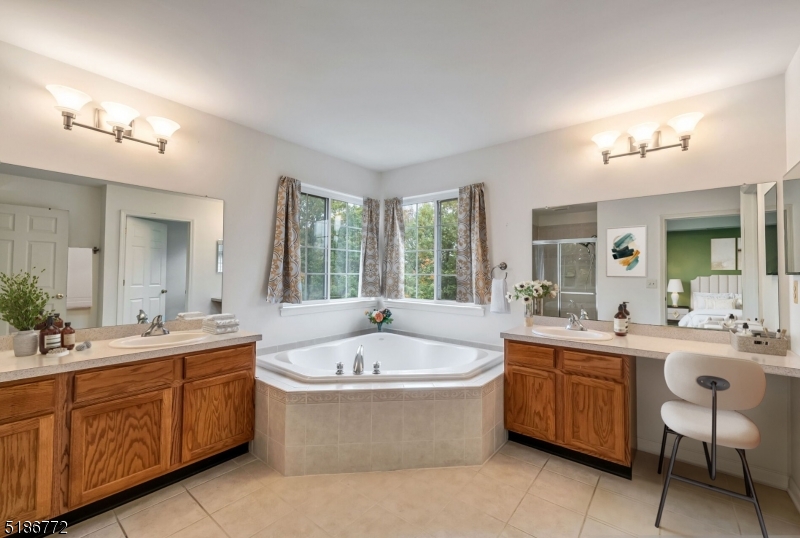 89 Hill Hollow Road Lake Hopatcong, NJ 07849 - Photo 15 of 25 a large spacious bathroom with a double vanity sink a large mirror and a bathtub