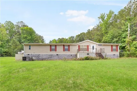 a front view of a house with a yard and trees