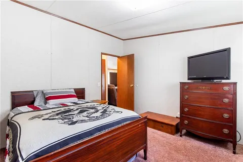 a bedroom with a bed and flat screen tv