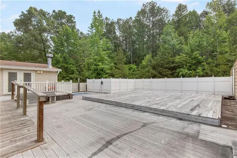 a backyard of a house with wooden floor and fence