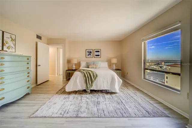 a bedroom with a bed and a refrigerator