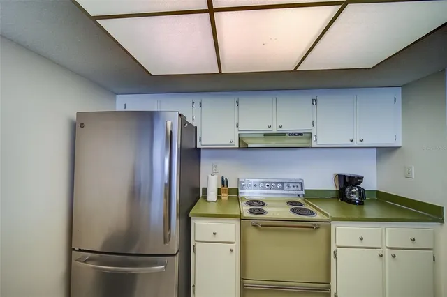 a kitchen with a sink and a stove with wooden floor