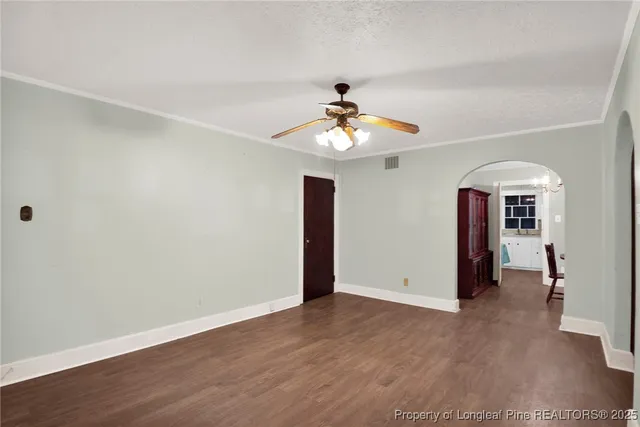 an empty room with fireplace cabinet and windows