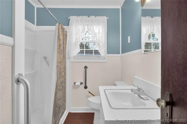 a bathroom with a sink a toilet and shower