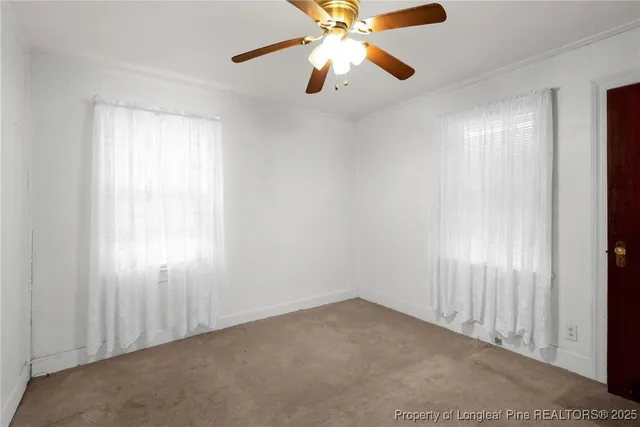 an empty room with closet and a chandelier fan