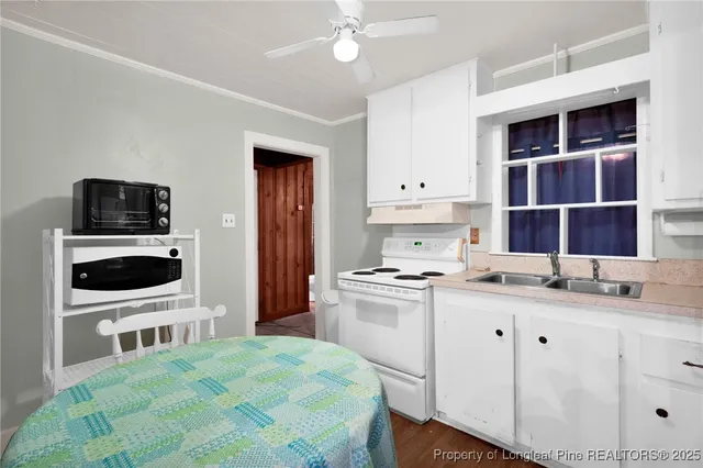 a kitchen with a stove a sink and a microwave