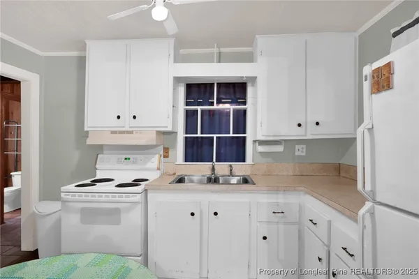 a kitchen with granite countertop white cabinets and stainless steel appliances