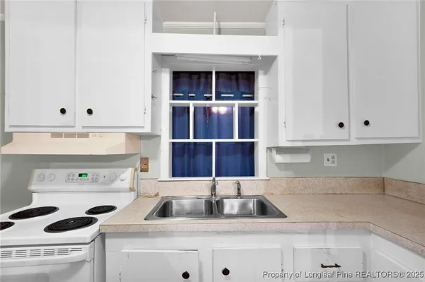 a kitchen with a sink a stove and cabinets