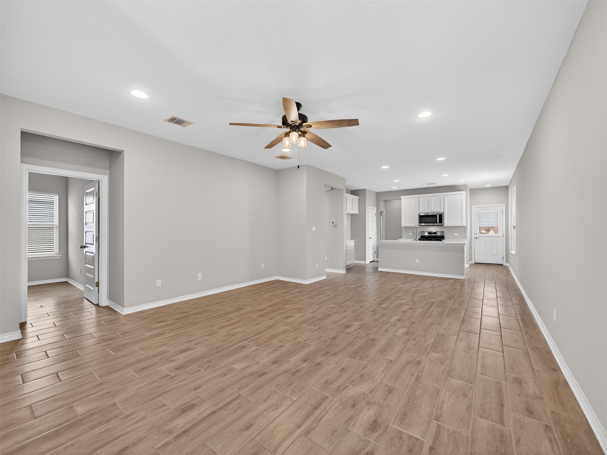 521 Rearing Mare Pass Georgetown, TX 78626 - Photo 5 of 39 a view of a big room with wooden floor and a ceiling fan