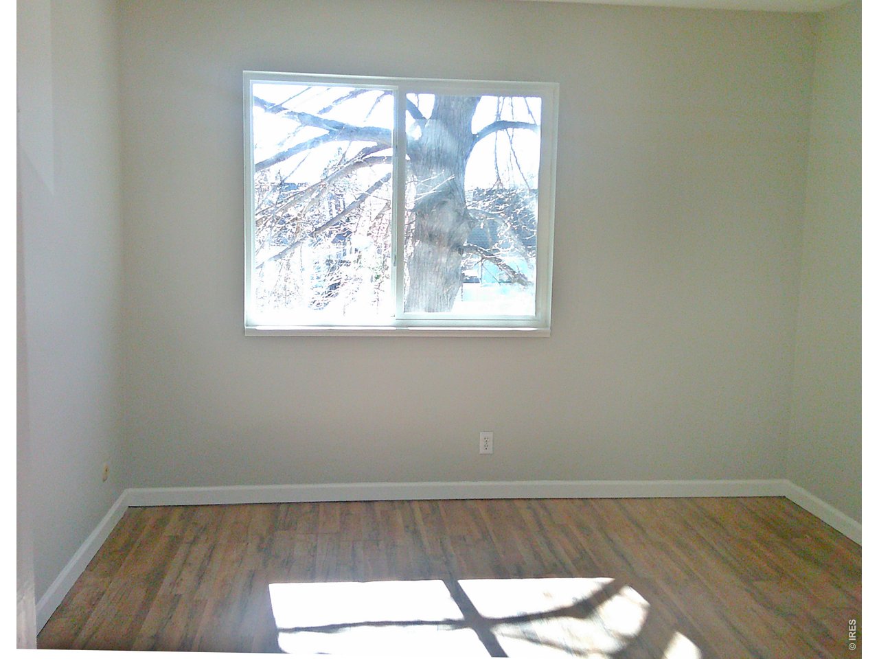 1165 South Oneida Street, Unit E Denver, CO 80224 - Photo 16 of 18 an empty room with wooden floor and windows
