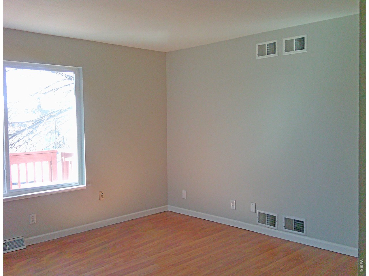 1165 South Oneida Street, Unit E Denver, CO 80224 - Photo 10 of 18 a view of an empty room with wooden floor and a window