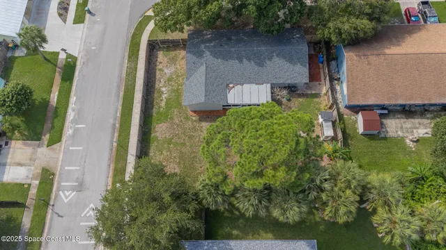 a white house that has a tree in it with a big yard and large trees