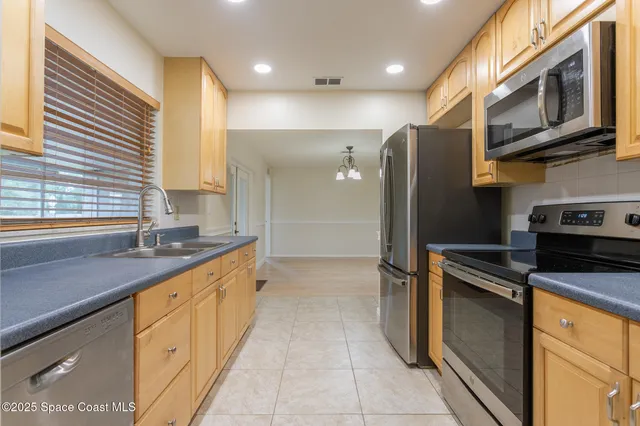 a kitchen with stainless steel appliances granite countertop a refrigerator a stove a sink and dishwasher