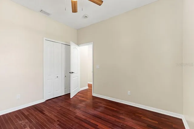 a view of an empty room with wooden floor