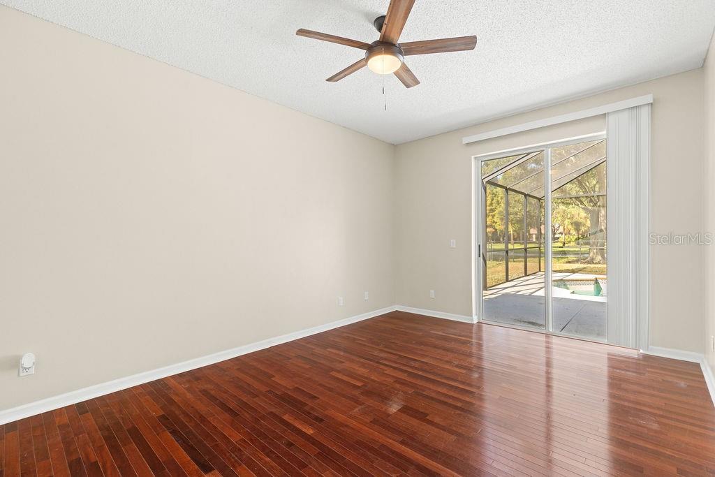 10641 Firebrick Court Trinity, FL 34655 - Photo 18 of 47 an empty room with wooden floor fan and windows
