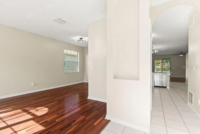 a view of a hallway with wooden floor and a bathroom