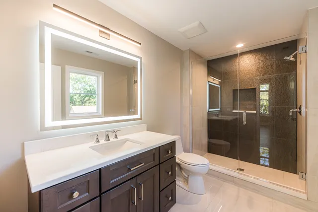 a bathroom with a sink a toilet and shower