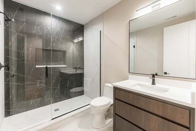 a bathroom with a sink a toilet and shower