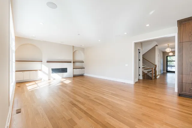 a view of empty room with wooden floor