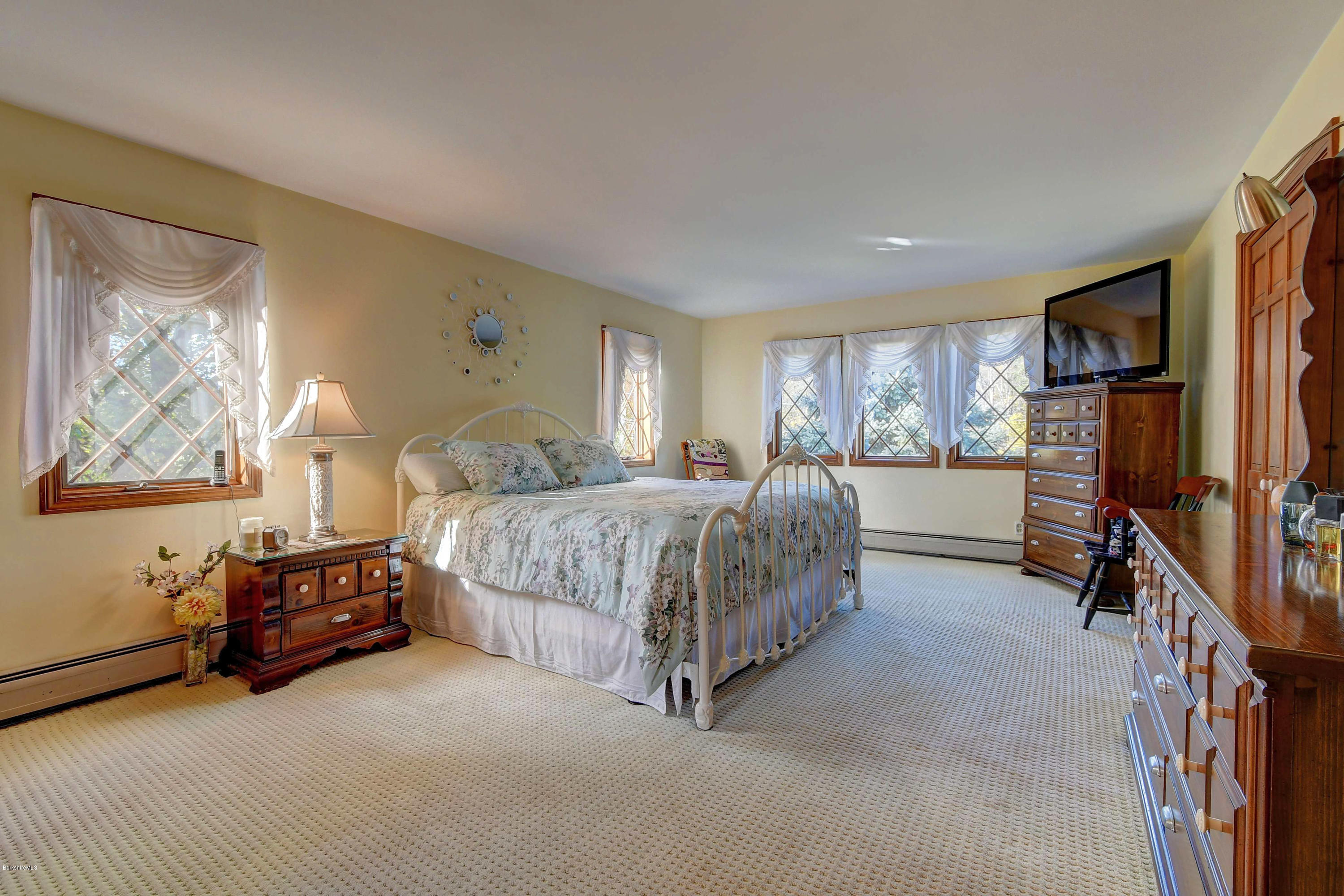 13 East Road Adams, MA 01220 - Photo 14 of 27 a spacious bedroom with a bed a couch and a window