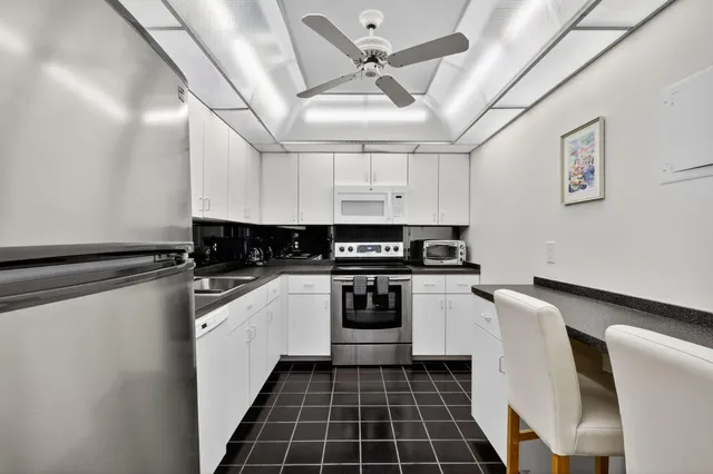 a view of a refrigerator in kitchen and an empty room