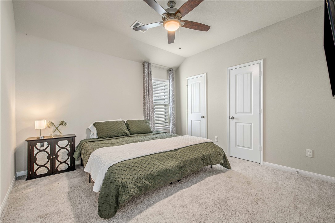 4703 Coyotillo Way Bryan, TX 77807 - Photo 17 of 24 a bedroom with a bed and a chandelier