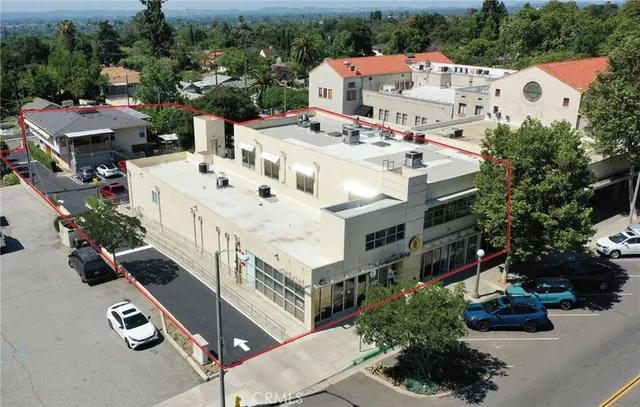 a view of a white house with large windows next to a road