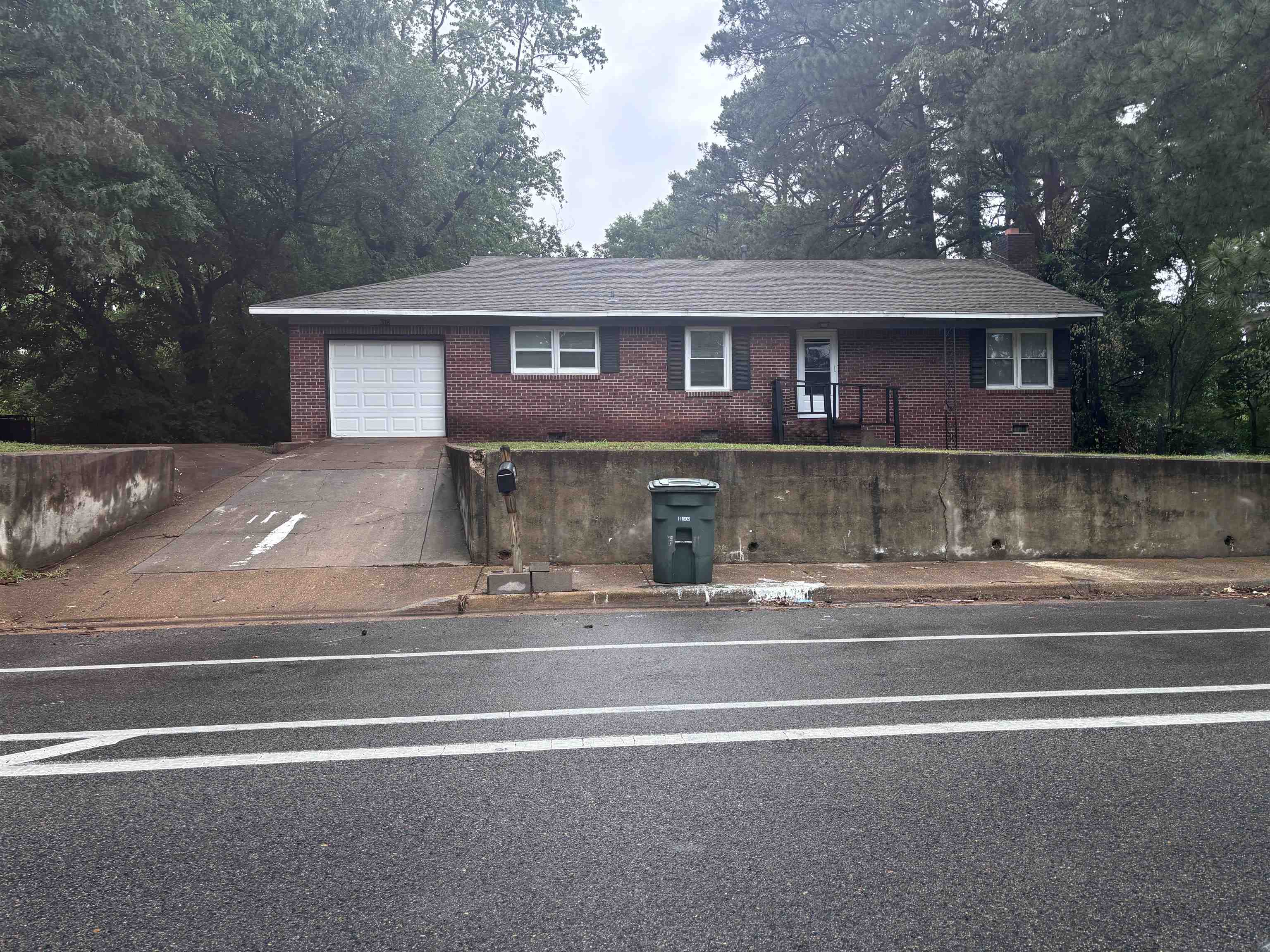 a front view of a house with a garden and garage